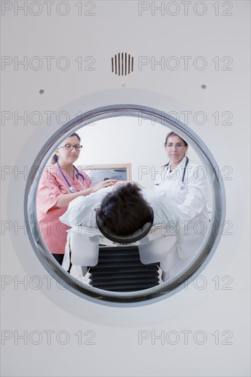 Hispanic doctor and nurse comforting patient at scanner