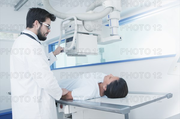 Hispanic doctor comforting patient at x-ray machine