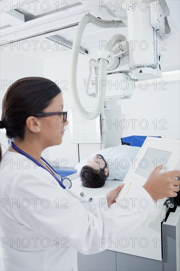 Hispanic doctor at control panel of x-ray machine