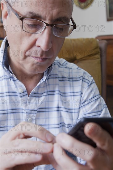 Hispanic man texting on cell phone