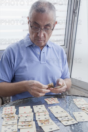 Hispanic man playing card game