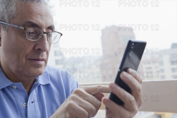 Hispanic man texting on cell phone