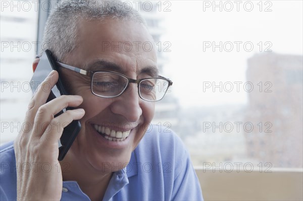 Smiling Hispanic man talking on cell phone