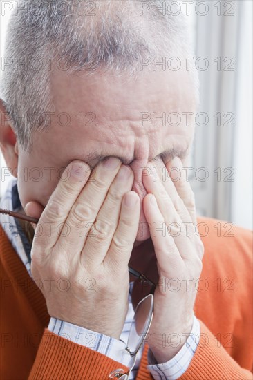 Hispanic man rubbing eyes