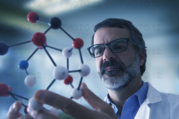 Hispanic scientist examining molecule model