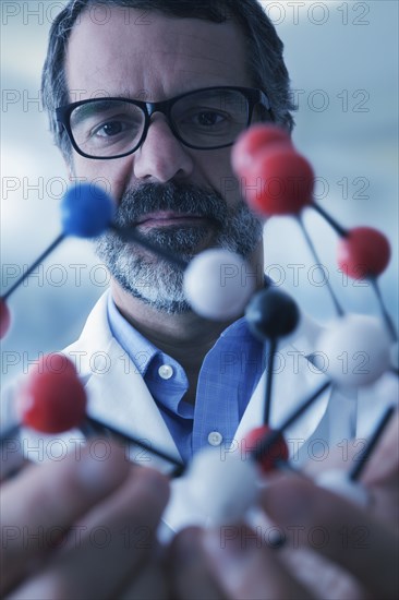 Hispanic scientist examining molecule model