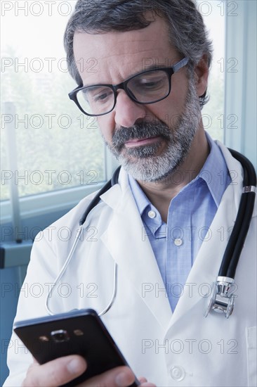 Hispanic doctor texting on cell phone