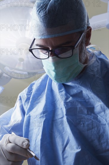 Hispanic surgeon holding scalpel