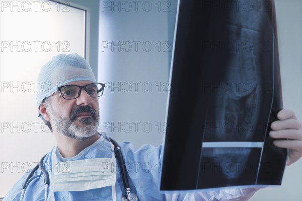 Hispanic surgeon examining x-ray