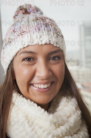 Portrait of smiling Hispanic woman wearing hat and scarf