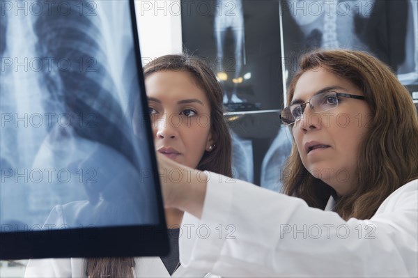 Hispanic doctors examining x-ray of chest