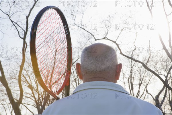 Rear view of Hispanic man holding tennis racket