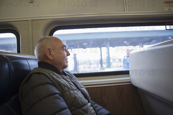 Hispanic man sitting on train