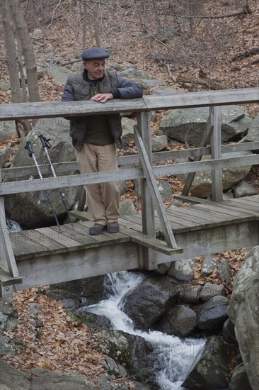 Hispanic man relaxing on footbridge