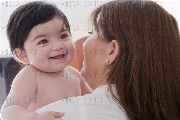 Hispanic mother carrying baby boy