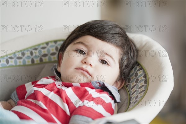 Hispanic baby boy laying in bassinet