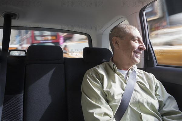 Smiling Hispanic man riding in car