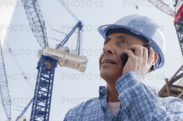 Hispanic construction worker talking on cell phone