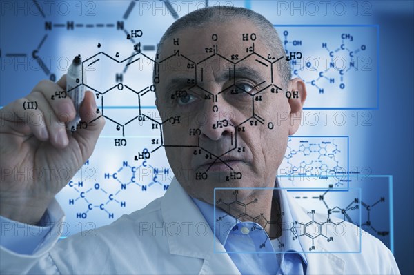 Hispanic scientist writing formula on glass wall