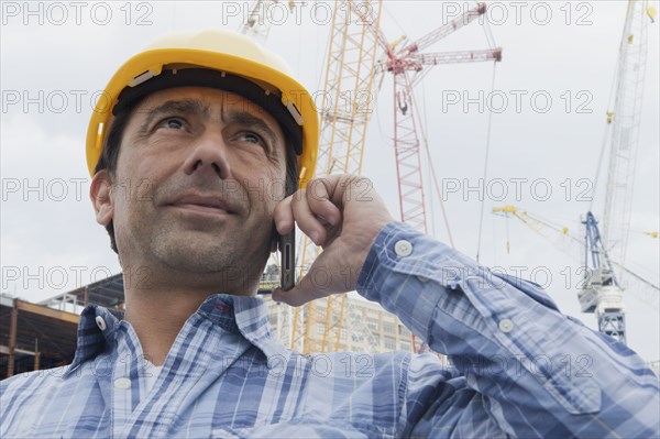 Hispanic construction worker talking on cell phone