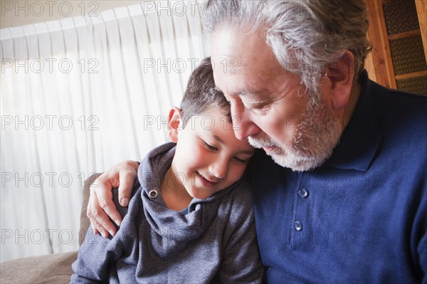 Hispanic grandfather hugging grandson