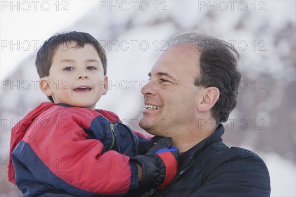 Hispanic father holding son