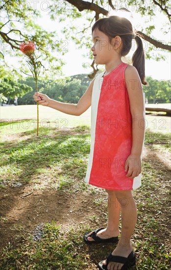 Mixed race girl holding exotic flower