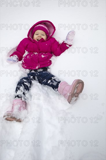 Grinning girl laying in snow