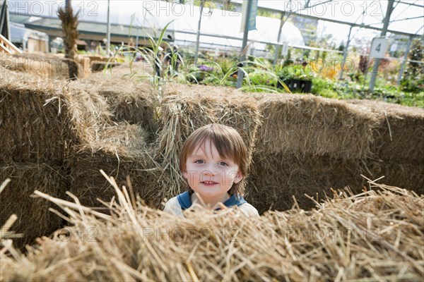 Caucasian boy standing near hay bales