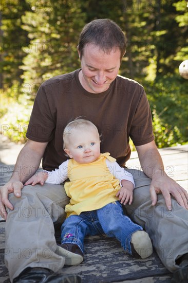 Caucasian father sitting with daughter