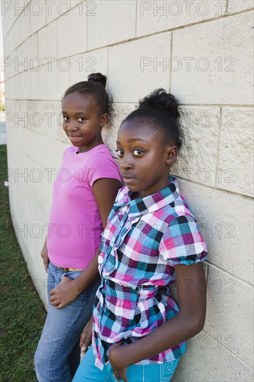 Black girls leaning against wall