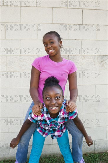 Black girl giving friend a piggyback ride