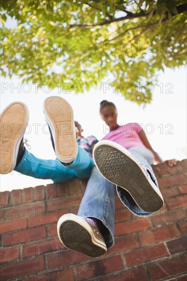Black girls sitting on wall