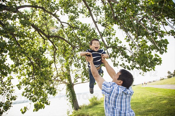 Japanese father playing with son in park