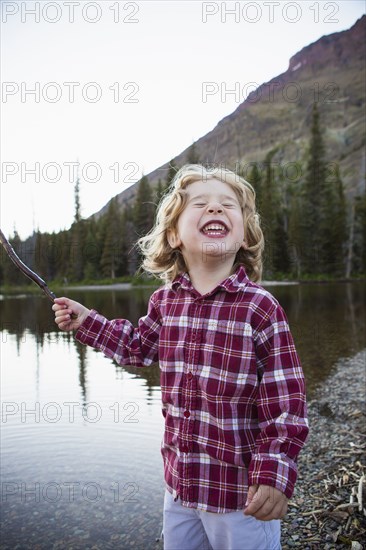 Boy making a face by still rural lake