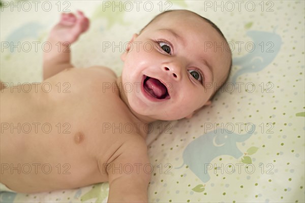 Smiling baby laying on blanket