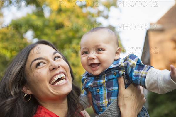 Smiling mother holding baby outdoors