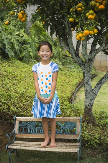 Mixed race girl smiling on park bench