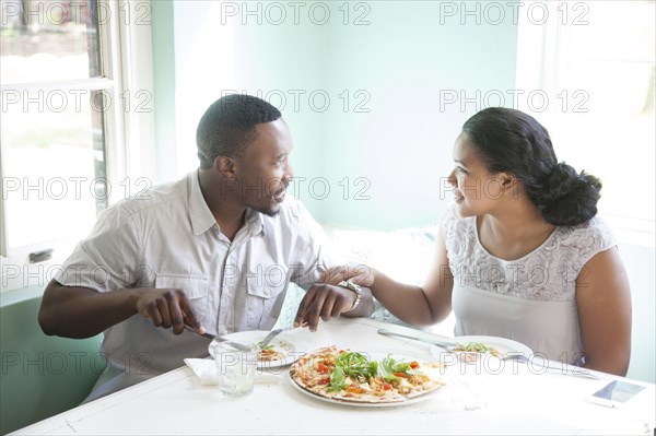 Smiling couple eating together at table