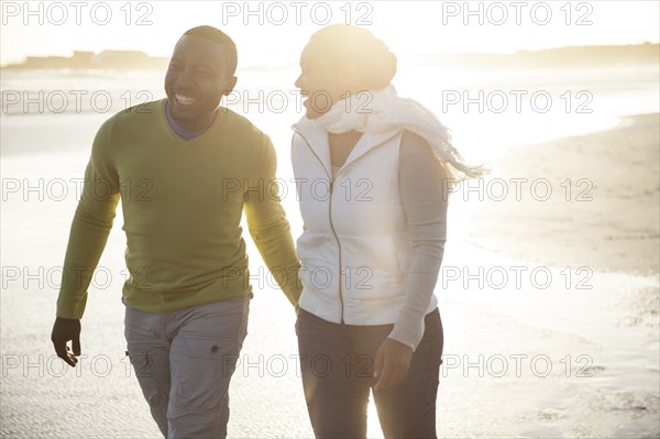 Smiling couple walking on beach