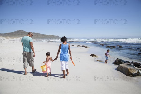 Mixed race family walking on beach