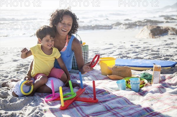 Mixed race mother and daughter playing at beach