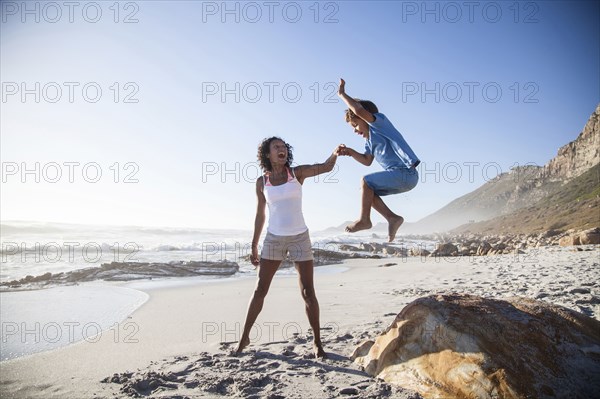 Mixed race mother and son playing on beach