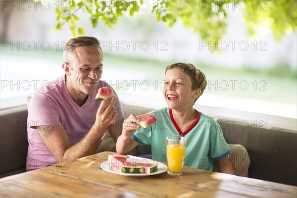 Caucasian father and son eating outdoors