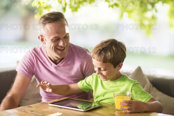 Caucasian father and son using digital tablet outdoors