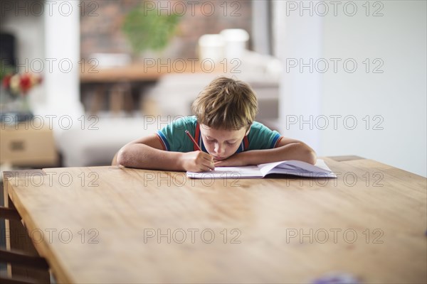 Caucasian boy drawing at table