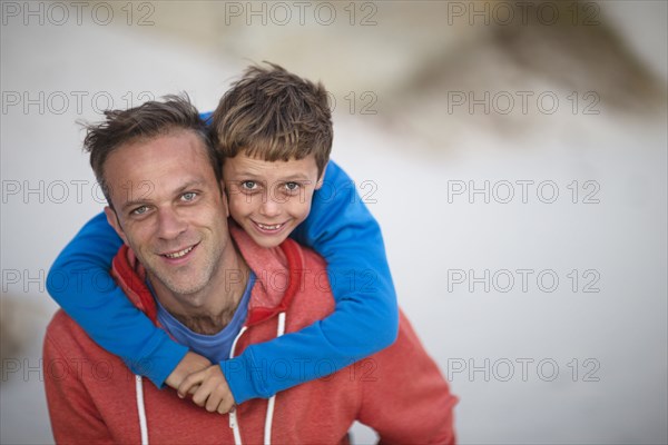 Caucasian father carrying son piggyback outdoors