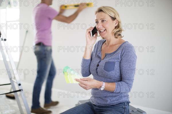 Caucasian woman talking on cell phone in new home