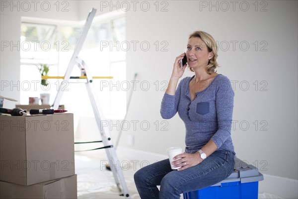 Caucasian woman talking on cell phone in new home