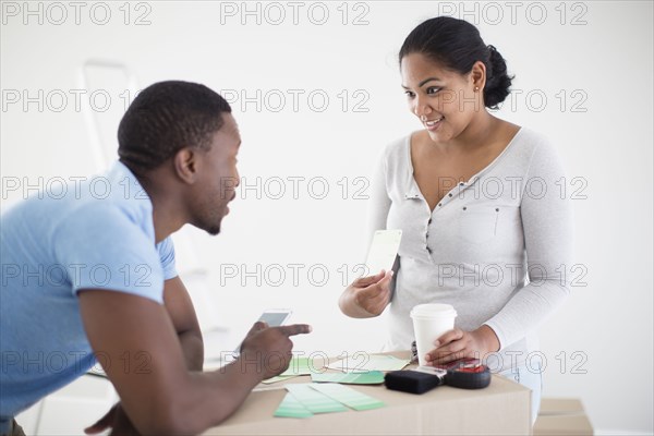 Couple choosing paint swatches in new home